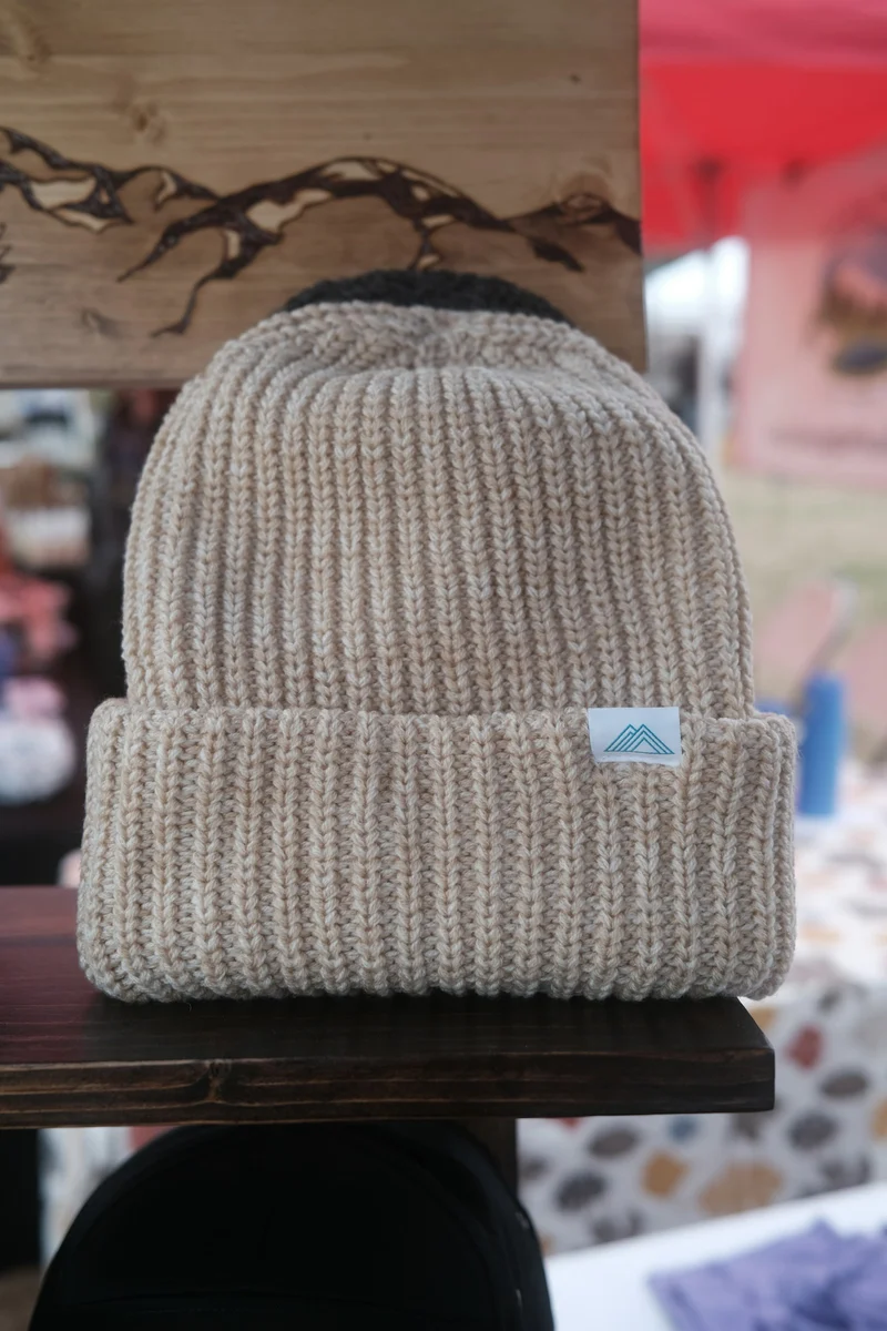 Ribbed knit beanie in oatmeal on a table (demo photo)