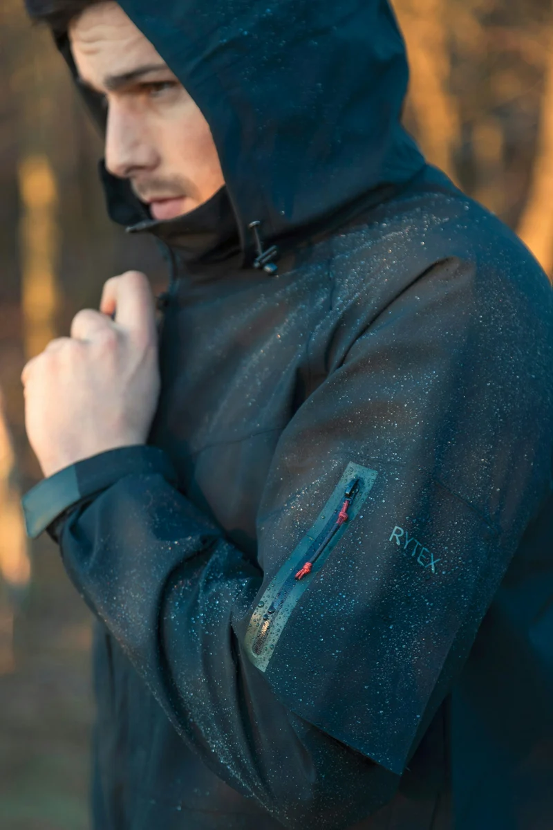 Close view of a hooded waterproof jacket in dark blue (demo photo)
